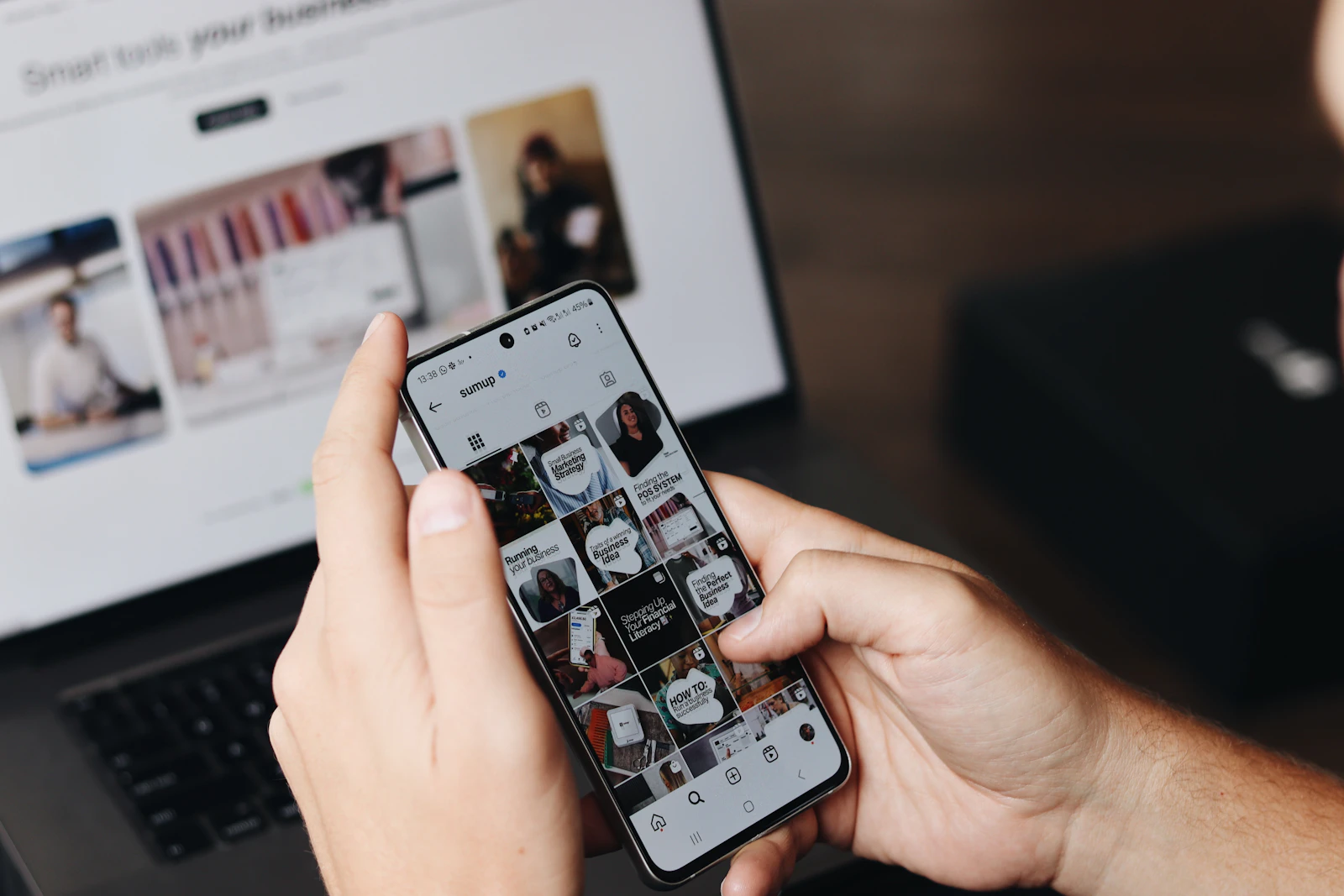 Social-Media-Inhalte auf einem Smartphone vor einem Laptop